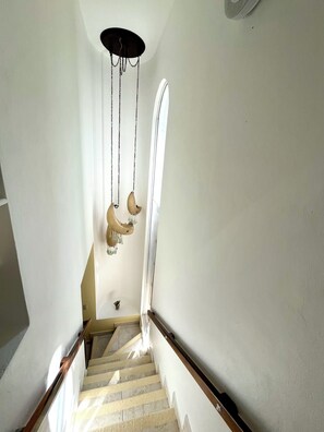 A staircase with a handrail, a ceiling light fixture, and a wall-mounted light. - Casa Corazon: a tropical boutique villa by the golf course, with a pool and a nearby beach (puerto aventuras)