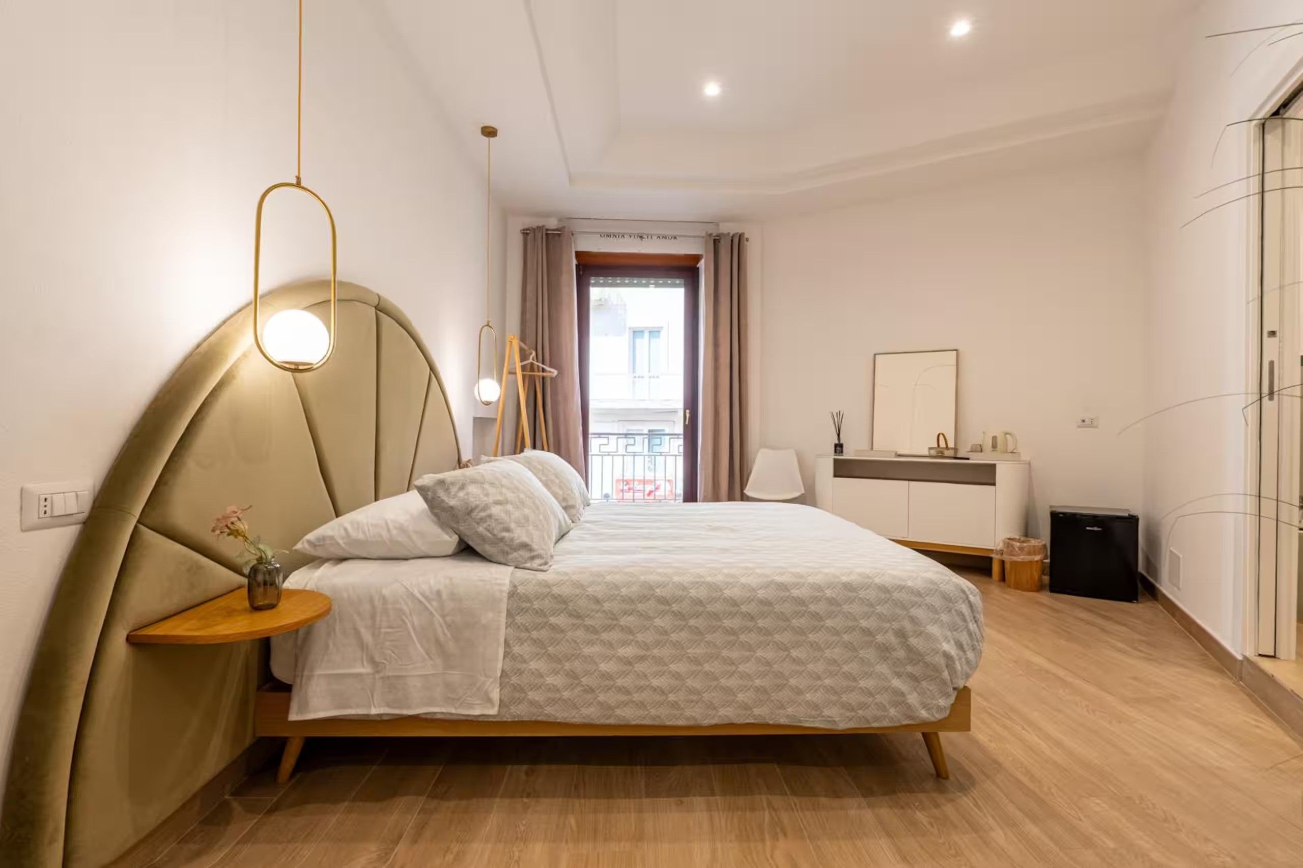 Una camera da letto moderna con un letto, un comodino, una lampada e vista all'esterno.