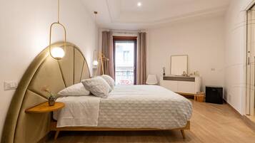 Una camera da letto moderna con un letto, un comodino, una lampada e vista all'esterno.