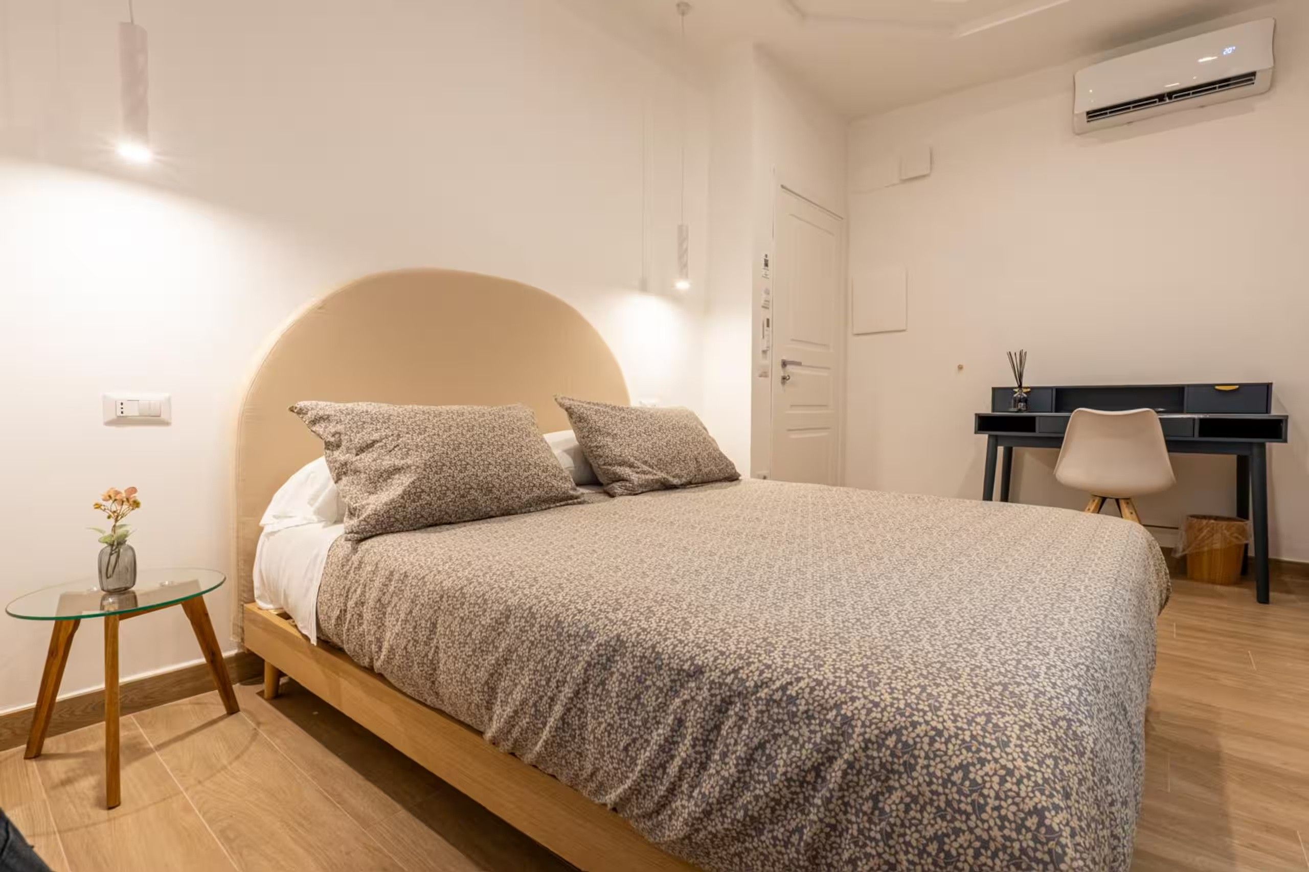Ein Schlafzimmer mit einem Bett, einem Nachttisch und einem Schreibtisch.