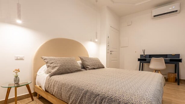 Ein Schlafzimmer mit einem Bett, einem Nachttisch und einem Schreibtisch.