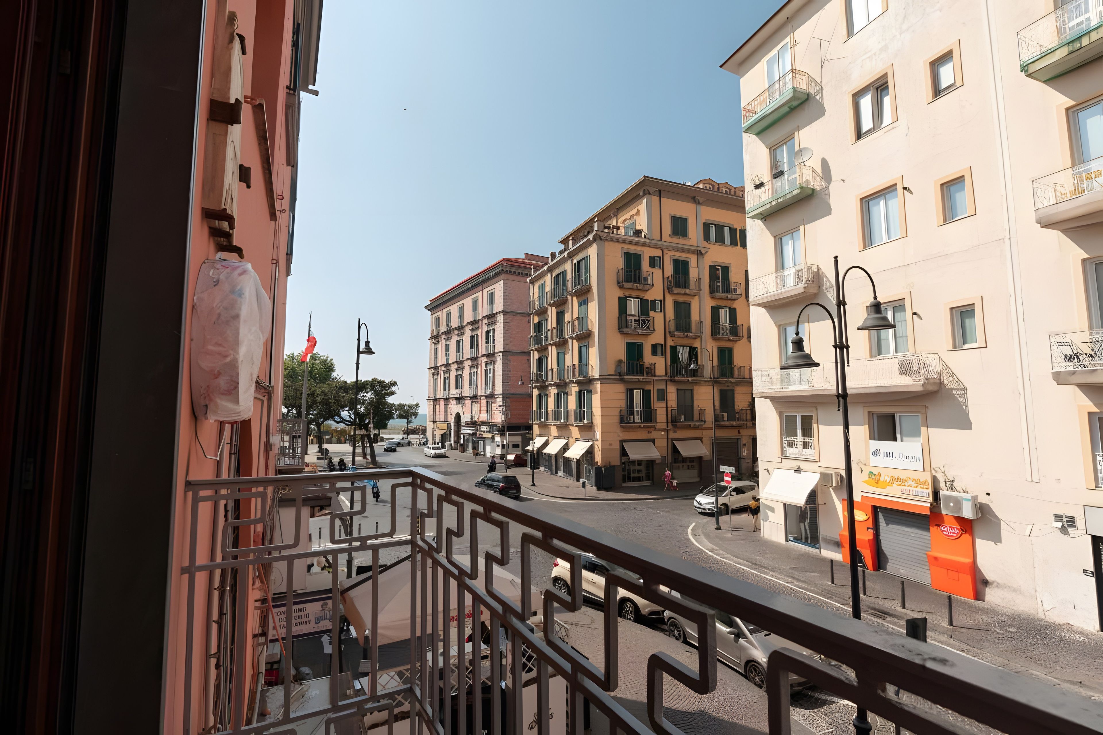 A street view with buildings, a pedestrian, and parked cars.