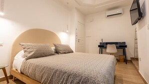 Une chambre à coucher comprenant un lit, un bureau et un appareil de climatisation.