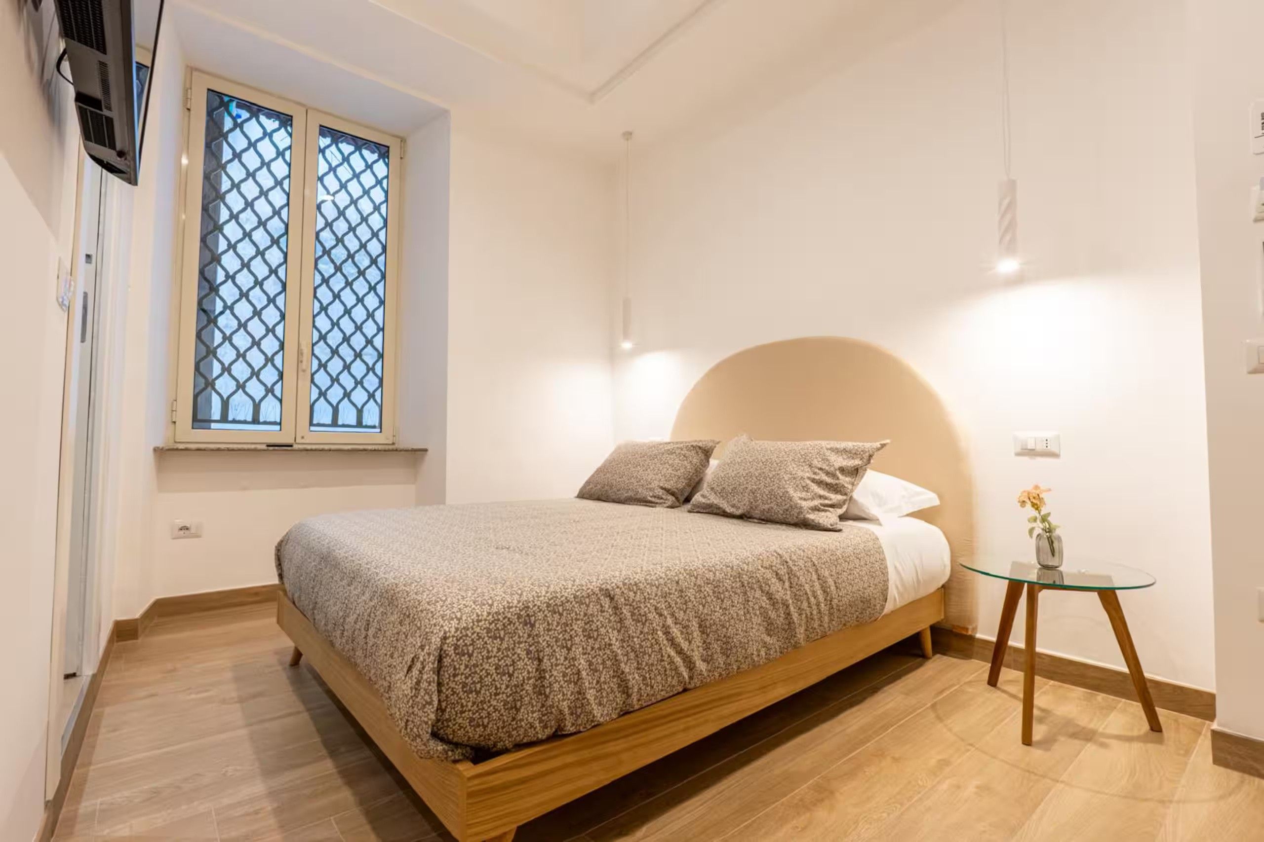 Una camera da letto con un letto, un tavolino, una finestra vista e un condizionatore d'aria a muro.