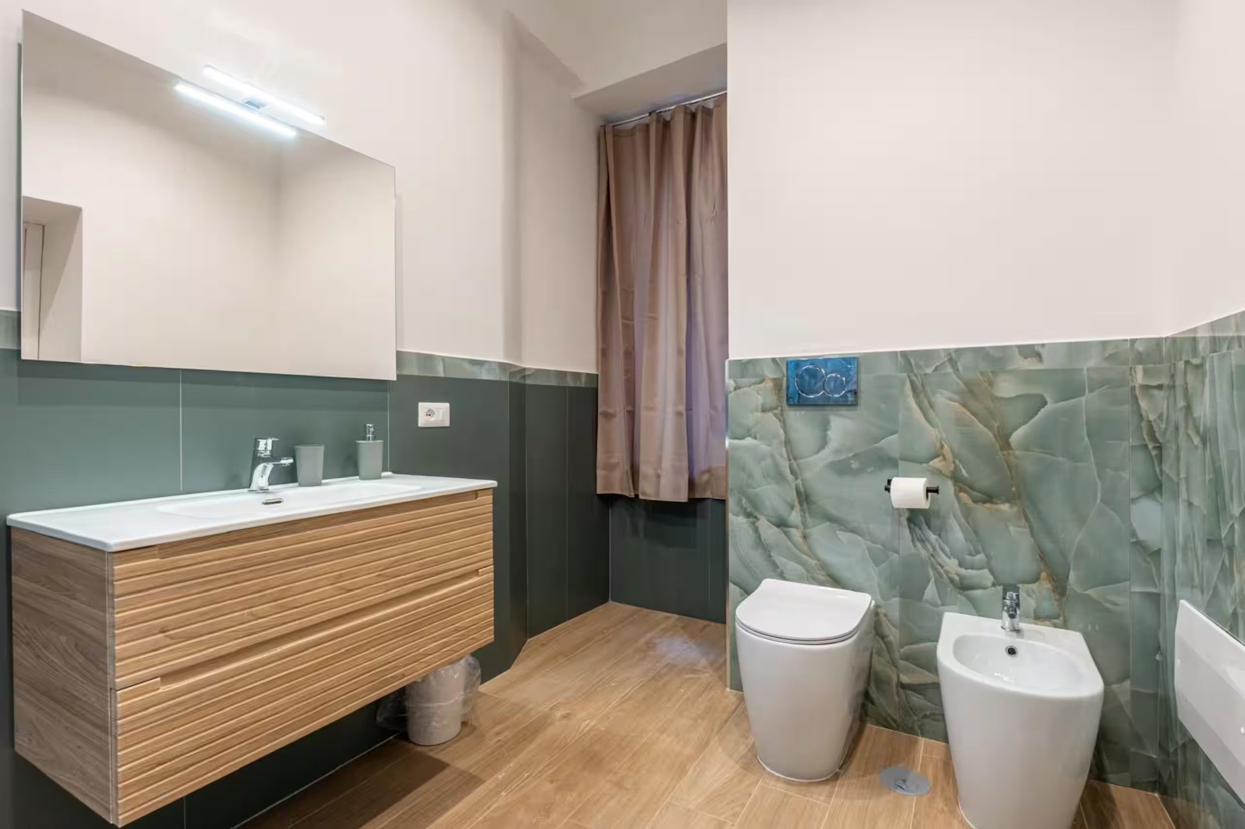 Ein modernes Badezimmer mit einem Holzbidet, einer Toilette und einem Waschtisch.