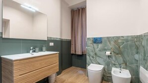 Ein modernes Badezimmer mit einem Holzbidet, einer Toilette und einem Waschtisch.