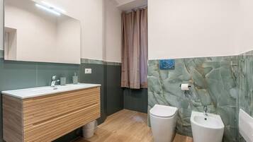 Ein modernes Badezimmer mit einem Holzbidet, einer Toilette und einem Waschtisch.