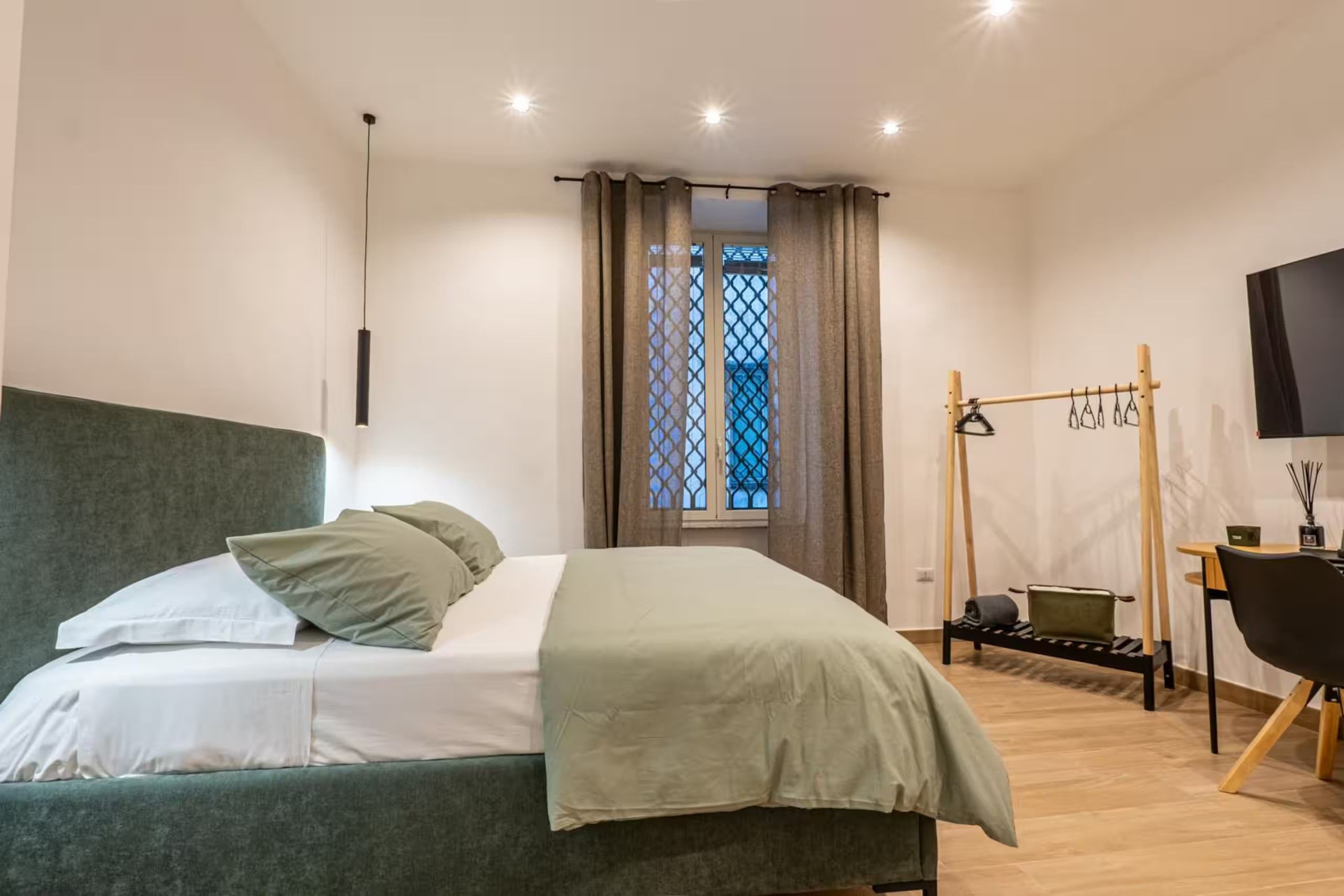 Una camera da letto moderna con un letto, una scrivania e un televisore.