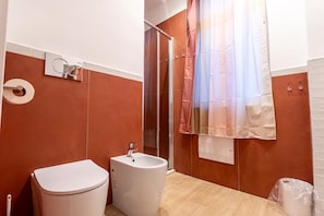 A bathroom with a toilet, bidet, and shower area. - Room 'Armonica Rooms - Camera Himeros' with Wi-Fi and air conditioning (Castellammare di Stabia)