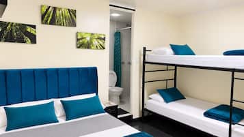 Una habitación con literas, una cama individual y zona de ducha.