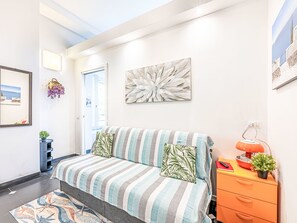 A bedroom with a bed, a nightstand, a lamp, and a wall with a painting. - Marienkäfer by Interhome (Corniglia)