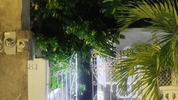 A gated entrance with a number '81' on the wall, surrounded by greenery.