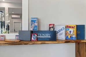 Une collection de jeux de société rangée sur une étagère en bois.