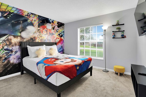Un dormitorio con cama, un mural grande en la pared, una ventana y una mesita de noche.