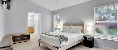 A bedroom with a bed, bedside table, and a ceiling fan.