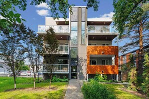 Een modern meerlaags gebouw met balkons en een opvallend verticaal element.