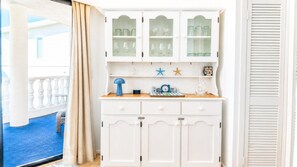 A white cabinet with glass-fronted upper compartments and a lower section with drawers. - **Between Two Blues – Beachfront Bliss in Yeppoon** (Yeppoon)