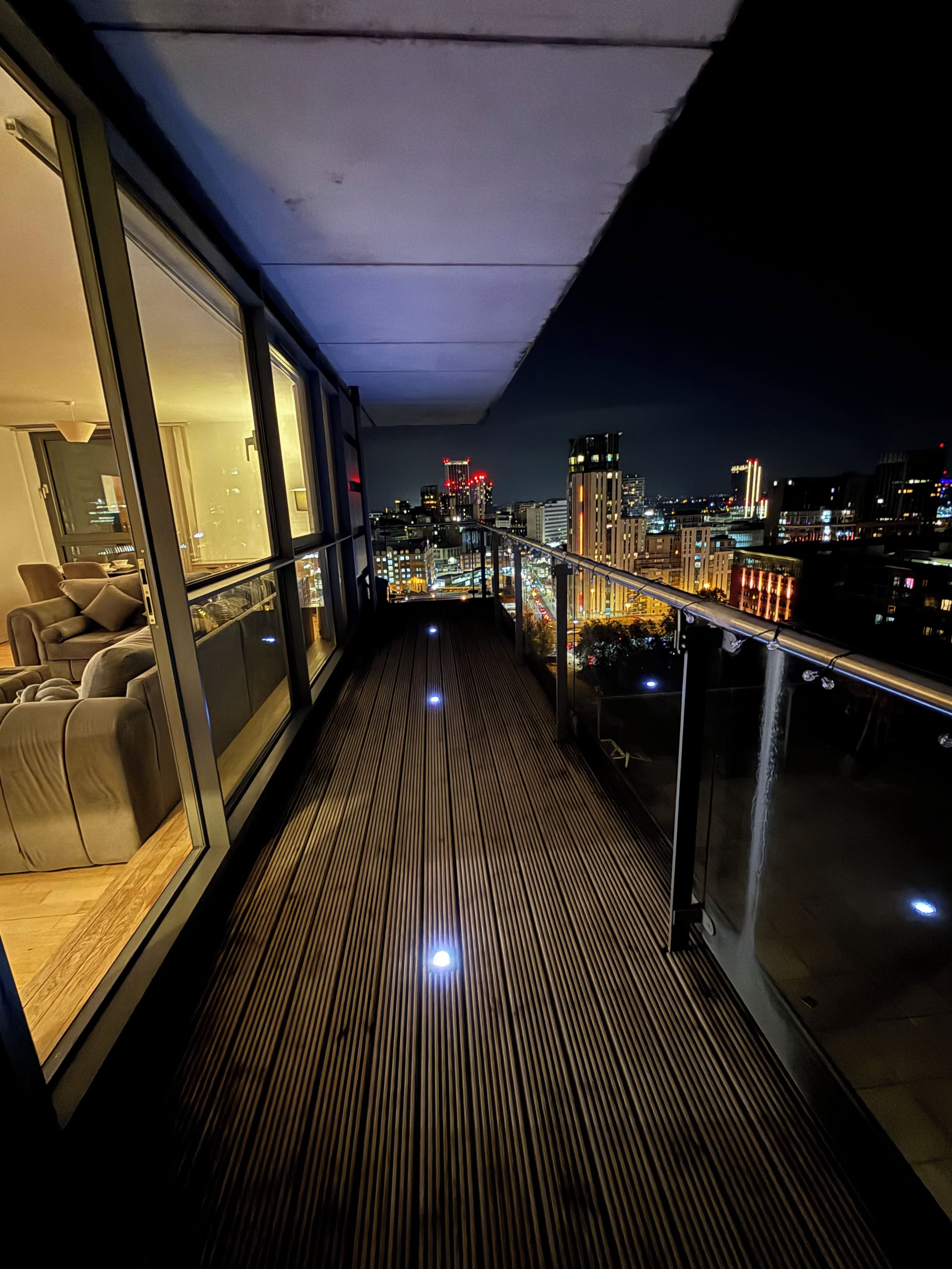 A balcony with a view of a cityscape at night.