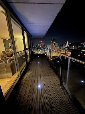 Ein Balkon mit Blick auf eine nächtliche Skyline.