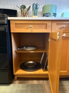 Eine Küche mit einem Holsschrank, einem Herd und einer Kaffeemaschine auf der Arbeitsfläche.
