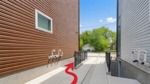Un étroit sentier mène à un bâtiment dont l’extérieur est en bois et qui possède une fenêtre.