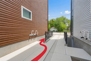 A narrow pathway leading to a building with a wooden exterior and a window. - Stylish 1BR Guest Suite | Near UofA, Whyte & DT - Double Room (Edmonton)