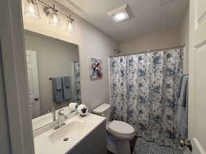 Ein Badezimmer mit Waschbecken, Toilette und Duschvorhang.