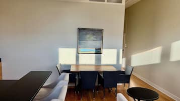 Une pièce comprenant une table à manger, des chaises, un canapé et un tableau accroché au mur.