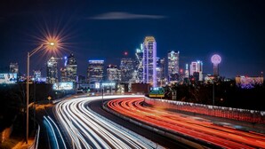 A nighttime cityscape with a curved highway and illuminated buildings. - Bishop Arts Studio w Parking Washer Dryer TV (Dallas)