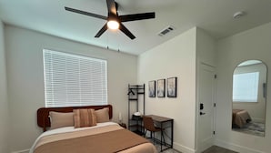 A bedroom with a bed, desk, chair, and a ceiling fan. - Bishop Arts 6BR 6BA Townhouse Sleeps 12 Parking (Dallas)