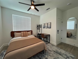 A bedroom with a bed, desk, chair, and a ceiling fan. - Bishop Arts 6BR 6BA Townhouse Sleeps 12 Parking (Dallas)