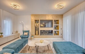 A modern living room with a sofa, a chair, a coffee table, and decorative items on the wall. - Cozy home in Zaton with sauna (Zaton)