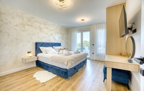 A bedroom with a bed, bedside table, and a desk with a mirror. - Cozy home in Zaton with sauna (Zaton)