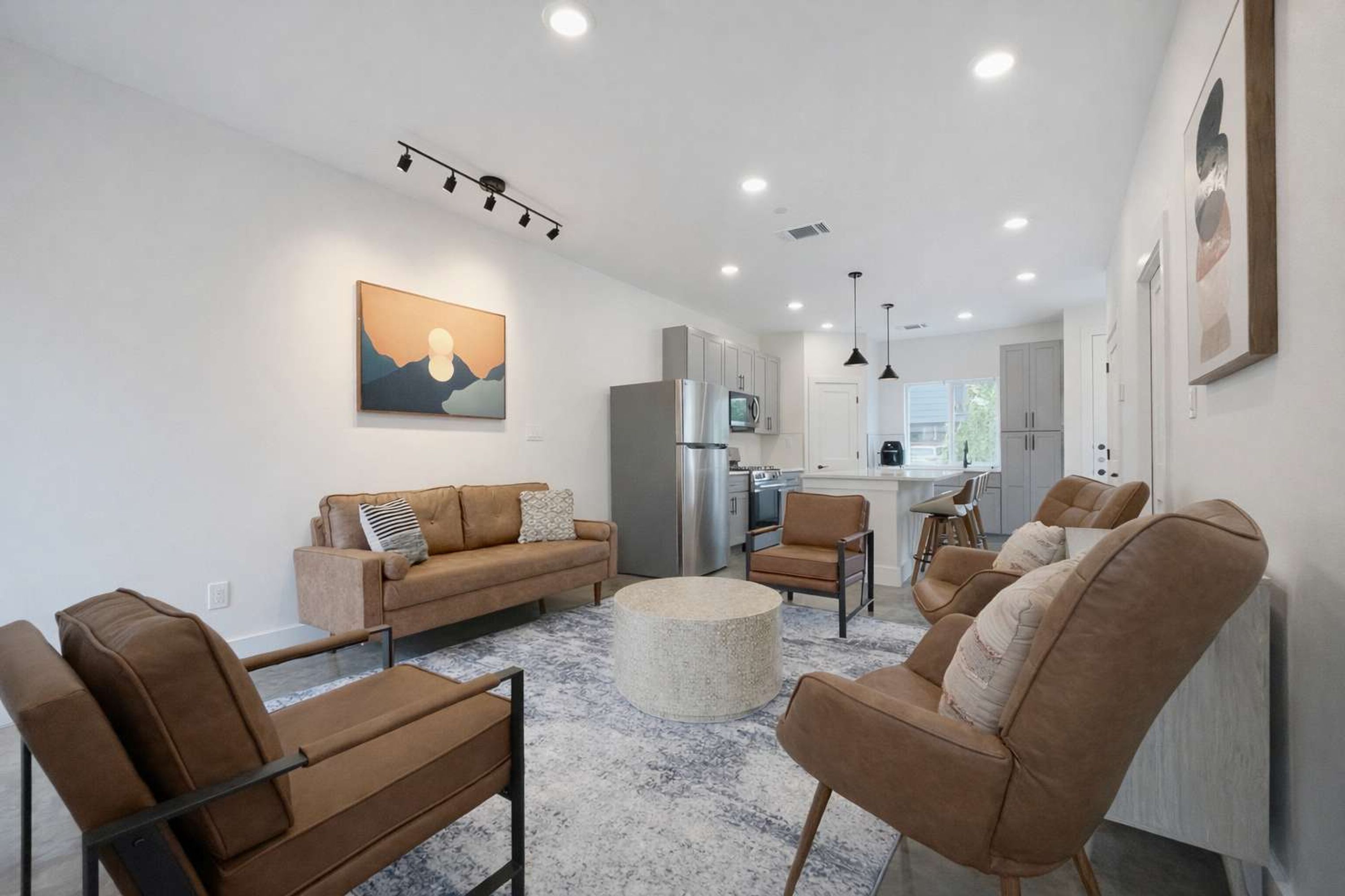 A modern living room with a sofa, chairs, and a coffee table.