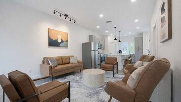 A modern living room with a sofa, chairs, and a coffee table.