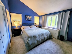 A bedroom with a bed, bedside tables, a window with curtains, and a world map on the wall. - Collinsville River Escape / Fall Foliage, Deck & Yard (Canton)