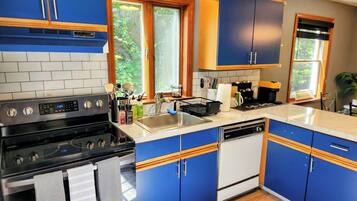Uma cozinha moderna com armários azuis, uma pia de aço inoxidável e uma lava-louças.