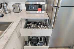 A kitchen with a microwave, toaster, and refrigerator. - The Getaway • 2BR • Parking • AC • Mins to DT (Edmonton)