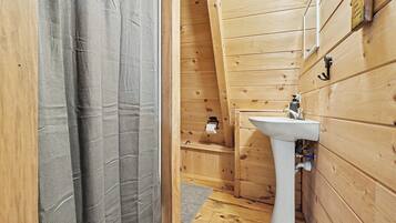 Un intérieur en bois avec un évier blanc et un espace douche.