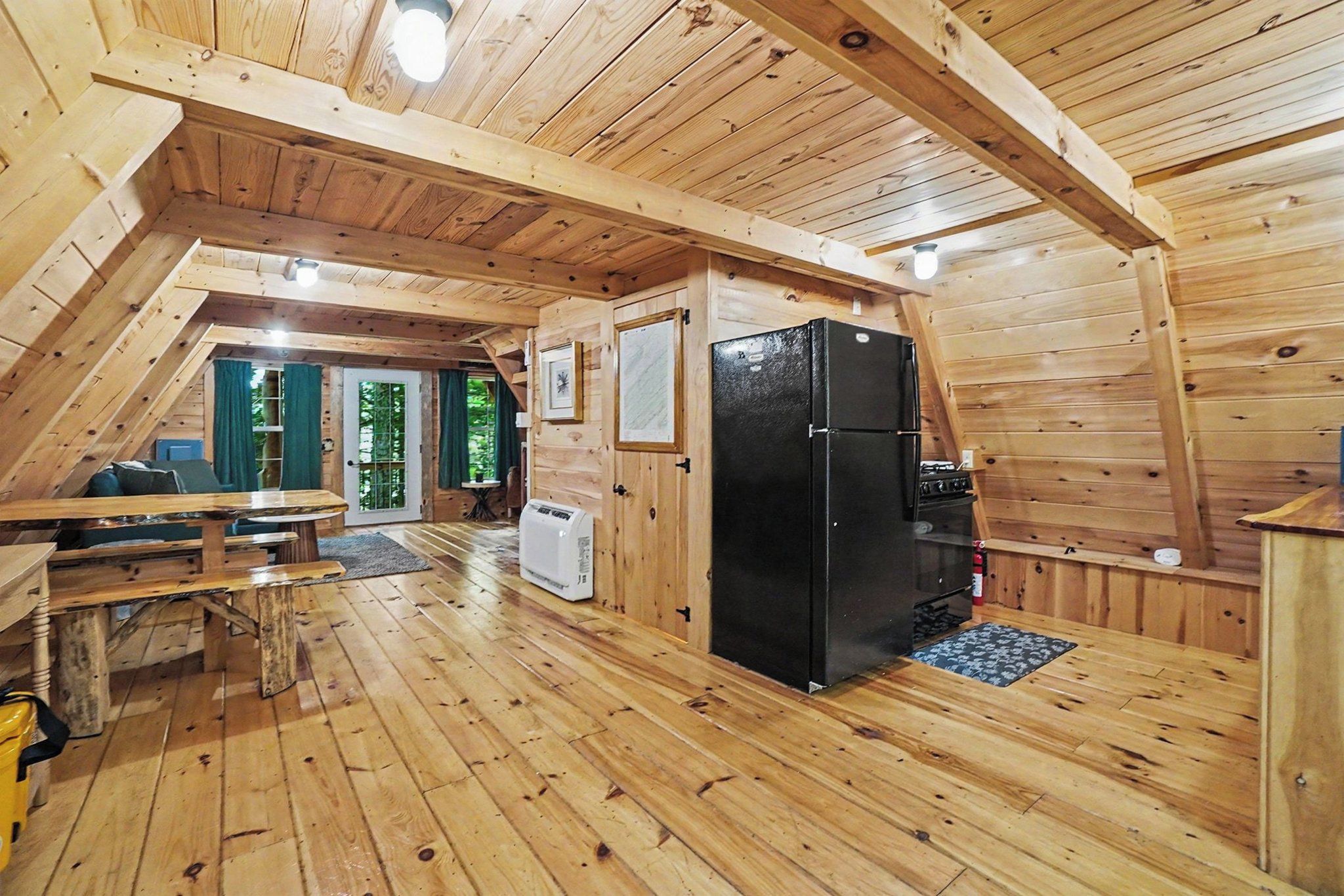 Un intérieur en bois comprenant une table à manger, des chaises, un réfrigérateur et une cuisinière.