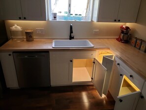 A kitchen with a dishwasher, a sink, and a window above it. - Restored 1930s Dehesa Valley Farmhouse, close to Sycuan Casino and more! (El Cajon)
