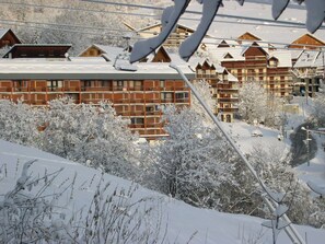 A snow-covered mountain resort with wooden buildings and ski lift infrastructure. - 2-STAR STUDIO FOR 4 PEOPLE AT THE FOOT OF THE SLOPES. Housekeeping. Weekends and staggered work weeks available upon request. (Saint-Sorlin-d'Arves)