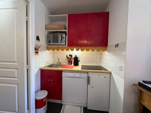 Eine kleine Küche mit Mikrowelle, Spüle und Geschirrspüler.
