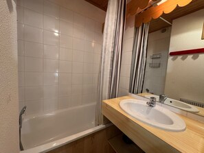Ein Badezimmer mit einer Badewanne, zwei Waschbecken und einem Spiegel.