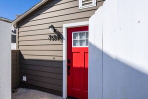 A building with a red door and a mailbox on the wall. - Cozy Casa | La Mesa Classic Craftsman (La Mesa)