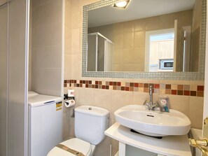Ein Badezimmer mit Toilette, Waschbecken und Spiegel.