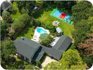 Ein Wohnhaus mit Schwimmbad, Tennisplatz und einer separaten Garage.