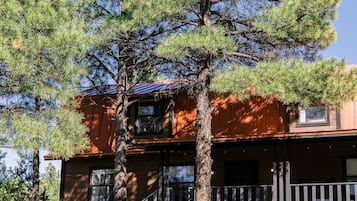 A two-story building with a wooden staircase leading to a balcony.
