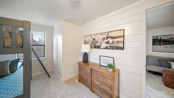 Una habitación con literas, un aparador de madera y un sofá.