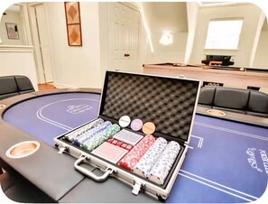 Ett pokerbord uppställt i ett rum med en vit dörr och en inramad tavla på väggen.